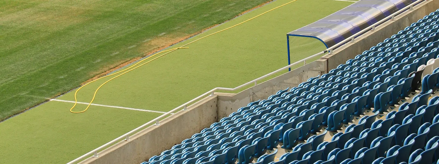 Les sièges d'une tribune et la pelouse d'un stade vide, vus d'en haut